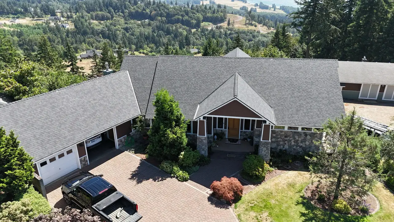 Drone aerial of a large Tudor-style Clark County, WA home with a Quality Master roof
