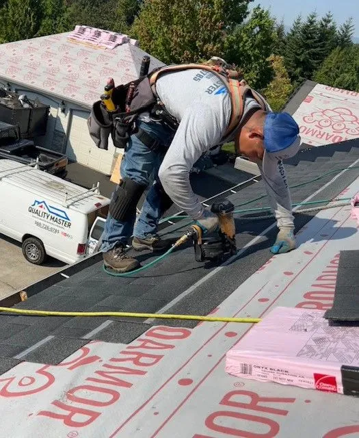 Roofer repairing storm-damaged shingles on a Clark County, WA home